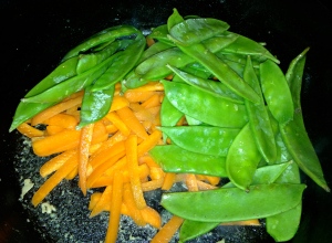 In the same skillet, add the carrots and snow peas.