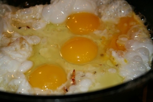 Crack eggs into hot oil and cook until firm, looking almost as if they are scrambled.